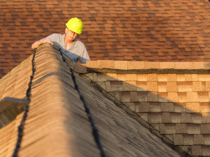 Roofer in Eatonton performing a winter roof inspection to assess repair needs.