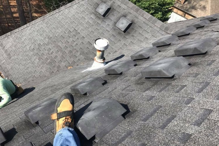 Professional Atlanta roof repair team inspecting a roof for summer storm readiness.